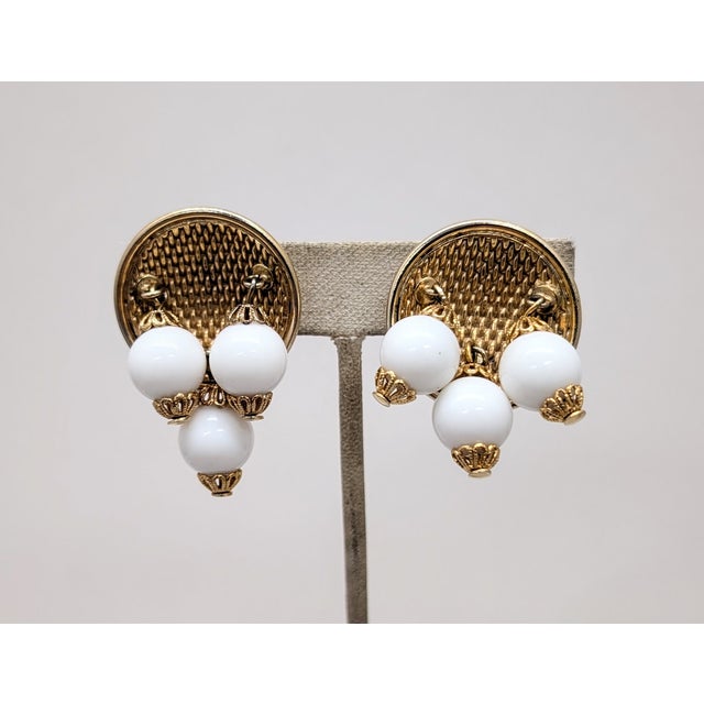 1950s round goldtone "woven" texture back with three white resin drops with filigree tops and bottoms clip back earrings....