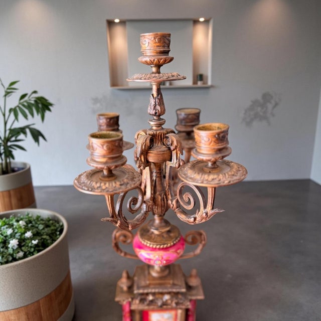 19th-century French garniture set featuring a central mantel clock flanked by two matching candelabra. This piece...