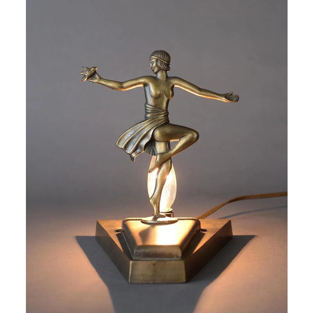 Stunning Art Deco lamp from Loevsky & Loevsky featuring a partially draped nude female holding a bird. Loevsky & Loevsky...