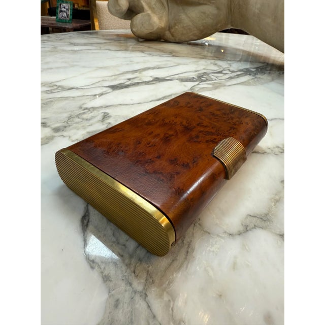 Elegant Art Deco cigarette case features a beautifully figured burl wood body complemented by brushed brass accents. The...