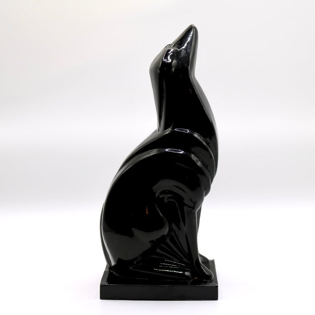 An exceptional and striking vintage Art Deco style sculpture depicting a sleek, stylized howling wolf (or canine). This...