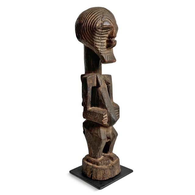 Antique early Songye female figure from the Democratic Republic of Congo, hand-carved from a single piece of hardwood and...