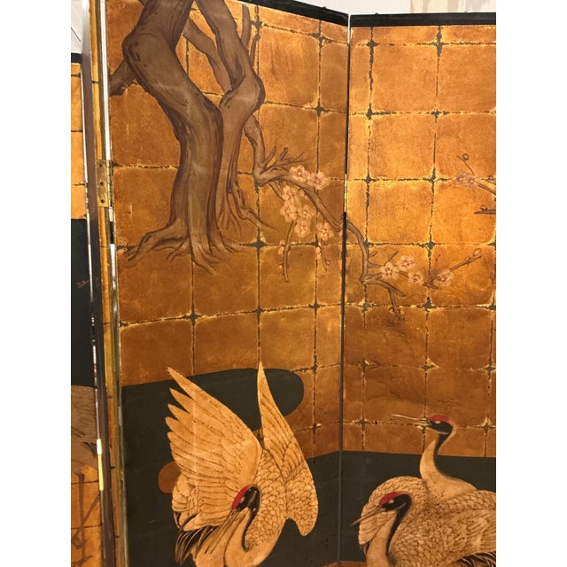 This is a vintage Asian four-panel folding screen featuring hand painted cranes and floral motifs on a gold leaf...