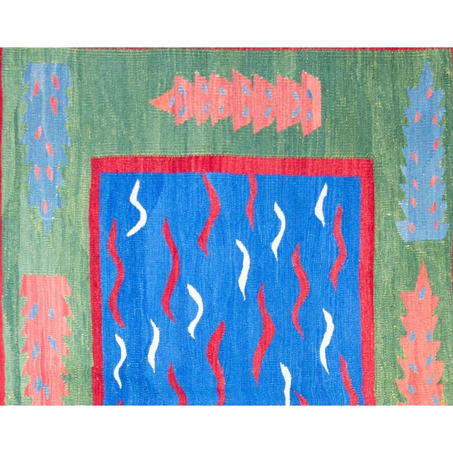 A bold and powerful late 20th century Turkish kilim rug with red and white wavy lines against a bright royal blue ground,...
