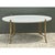 Distinguished by its graceful architectural lines, this vintage oval coffee table features a smooth white tray-style top...