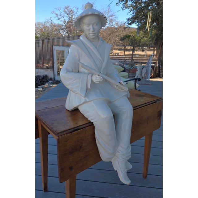 Vintage cast resin indoor or outdoor statue. There are losses to the thick white finish and the flute has been repaired....