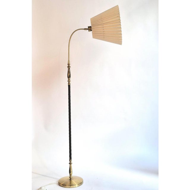 A rare floor lamp, model 5737 by Einar Bäckström. Made in solid brass with leather trim. with makers mark and model...