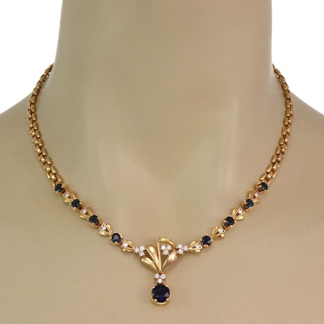 This elegant floral necklace is crafted from 18k yellow gold, the center piece has 4 round cut sapphire on each side,...