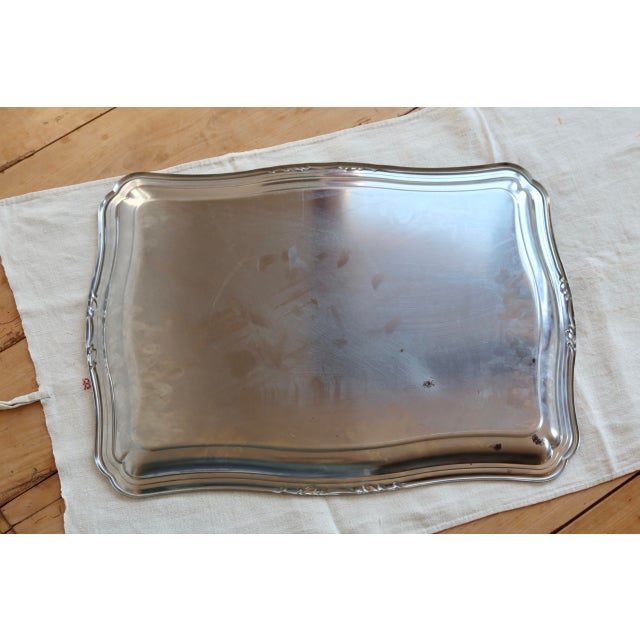 Extra-large silver-plated metal serving tray with an elegantly shaped rectangular silhouette and subtly decorated molded...