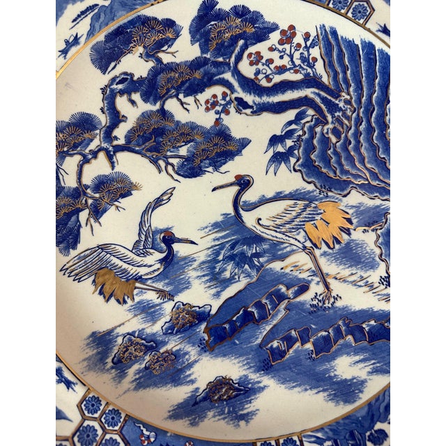 Very large Japanese dish in blue and white porcelain enhanced with gold dating from the 1950s. Decor of cranes in a marsh...