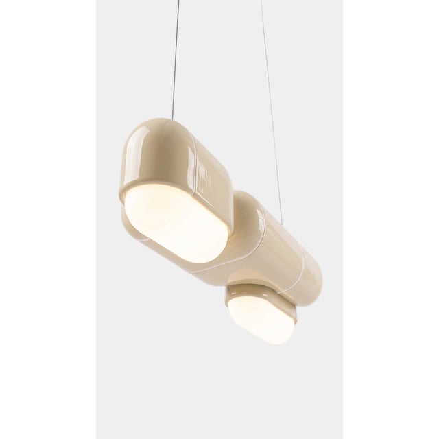 A pendant that changes with the day. In daylight its printed shell reads crisp and architectural, all shadow and ridge;...