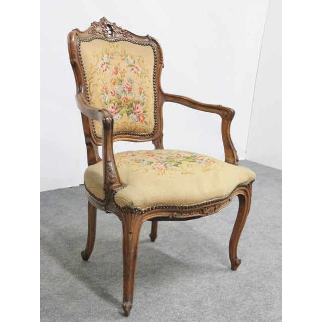 Carved walnut frame with scrolled feet. Floral needlepoint upholstery.