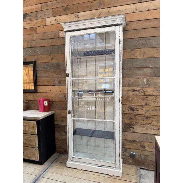 This antique, weathered display case has been fully restored. It is glass-enclosed on three sides, allowing for a...