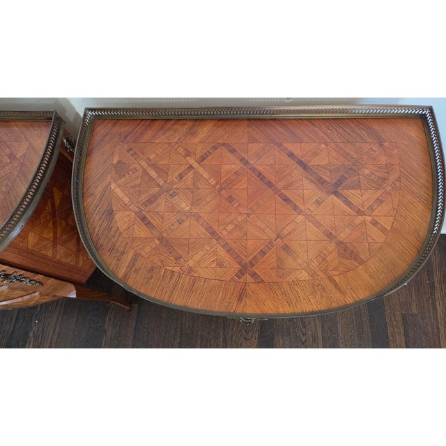 A matching pair of Italian bedside chests featuring intricate geometric parquetry, curved three-drawer fronts, and pierced...