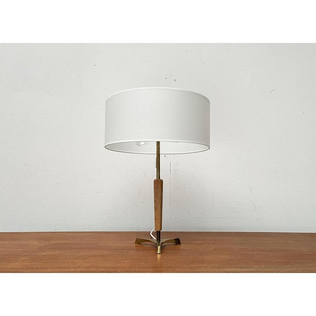 Rare Mid Century Tripod table lamp. An elegant design of special materiality. The brass is enclosed in the lower area with...