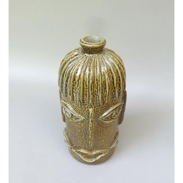 An extraordinary vase, studio ceramic, made by hand in the 1960s. The vase shows the shape of a bottle with 4 identical...