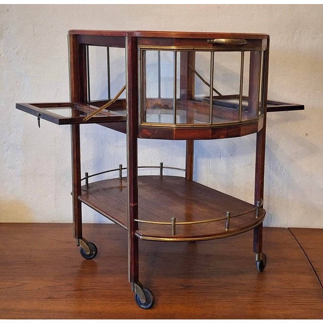 Serving trolley / bar cart in mahogany, brass and glass dating from about 1920. Beautifully designed piece with an...