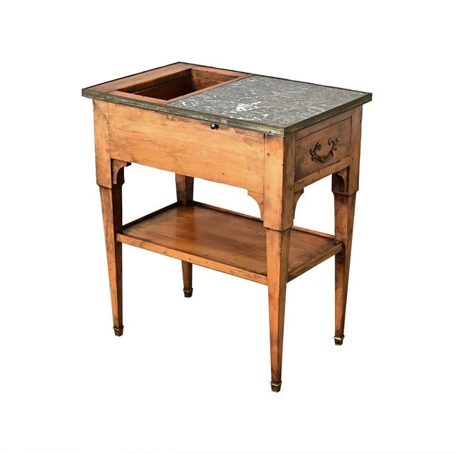 Dimensions: 27 ⅜” H x 15 ½” W x 24 ¼” D A French fruitwood and gray marble rafraîchissoir table from the late 19th century...