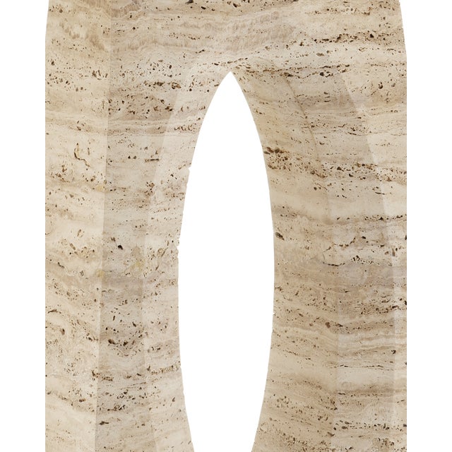 The Demi Travertine Console Table is made of solid travertine. A bevel softens the oval that is carved into the stone on...