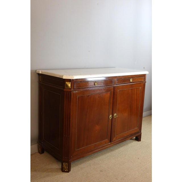 A mahogany and mahogany veneer sideboard with two drawers and two doors in the frieze. The uprights are fluted and the...