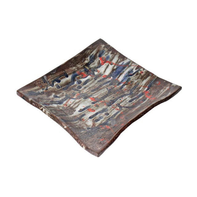 A studio pottery tile plate by American artist Toshiko Takaezu (1922-2011). This rectangular plate features a brown, blue,...