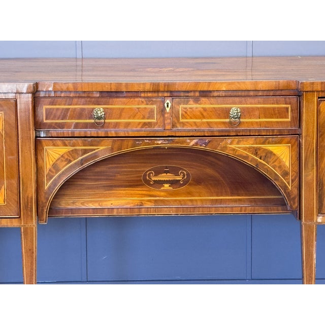 Serpentine-front sideboard with crossbanded mahogany top above a central section fitted with a single drawer (appearing as...