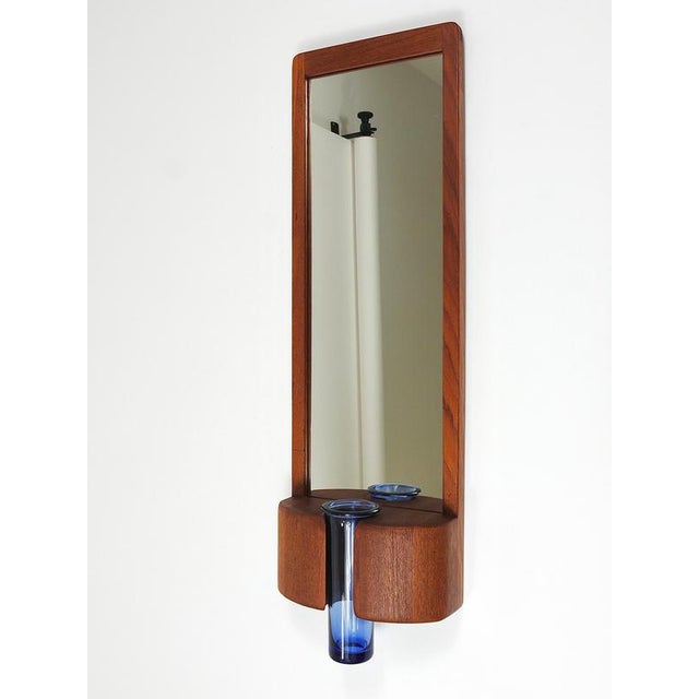 A wonderful and particularly decorative Mid-Century Modern wall-hanging mirror from the 1960s. This mirror is the result...