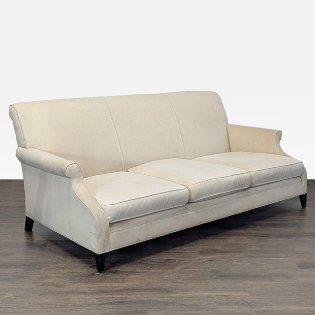 This Restoration Hardware 3-seat sofa features a clean cream fabric, classic rolled arms, and supportive back cushions....