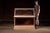 Early 20th-century painted wood commercial display case featuring a slant-front glazed upper showcase above a rectangular...