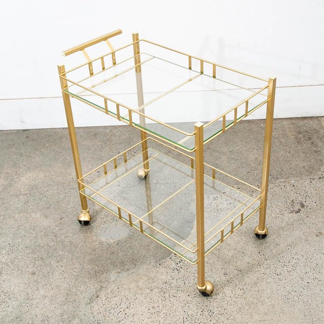 2 tier Rolling brass bar cart with glass shelves. Unknown American maker.