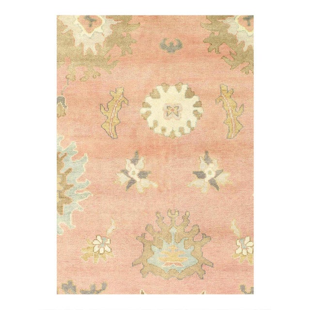 This Oushak Hand-Knotted Wool Pink/rose Area Rug celebrated for its understated elegance, is greatly influenced by...