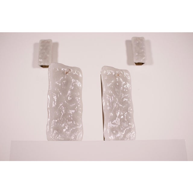 Pair of murano glass wall sconces with a translucent white glazed texture and dotted with inclusions, mounted on a gilded...