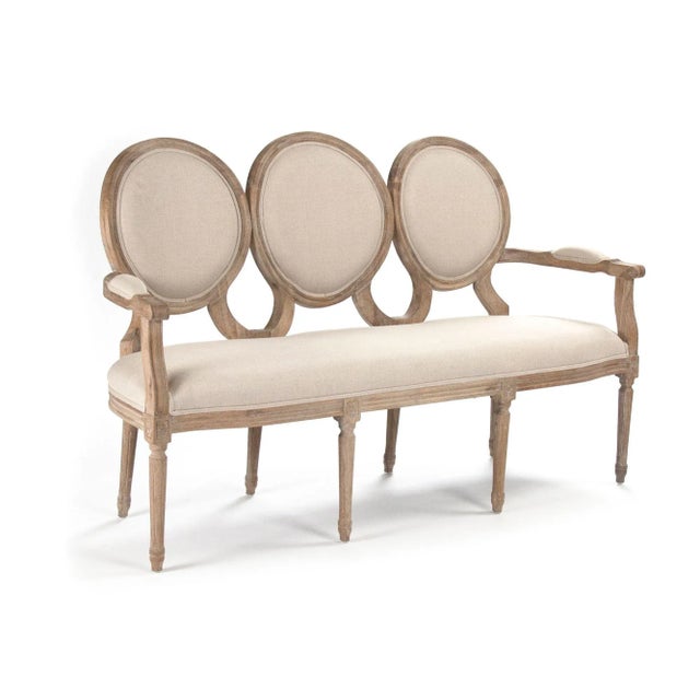 Settee upholstered in natural linen, padded arms on limed grey oak frame.