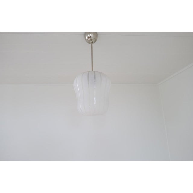 An art deco chrome and etched glass pendant light designed by harald notini and produced by arvid böhlmarks lamfabrik,...