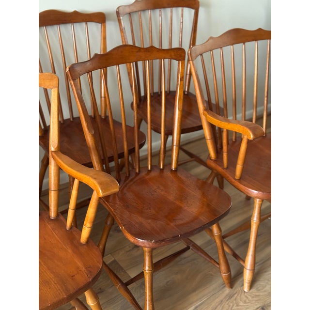 A set of six vintage Windsor-style dining chairs, including four side chairs and two armchairs. Crafted from solid wood,...