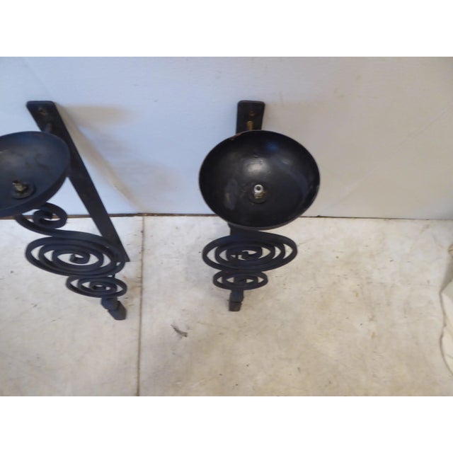Brutalist iron sconces, for candles, can be wired.