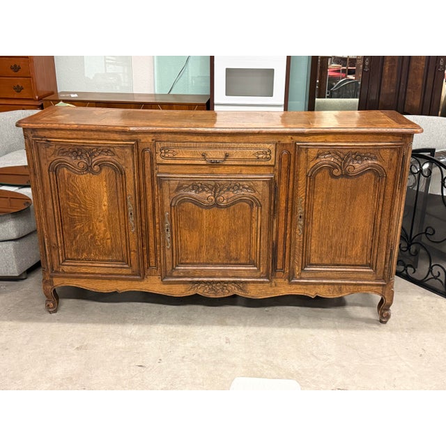 Design Plus Gallery presents an Antique French Louis XV Style Sideboard. Showcasing classic European form with ornate...