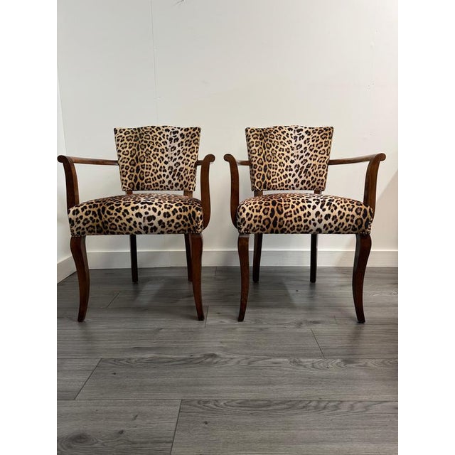 This striking pair of French 1940s armchairs balances mid-century architectural elegance with a bold, maximalist touch....