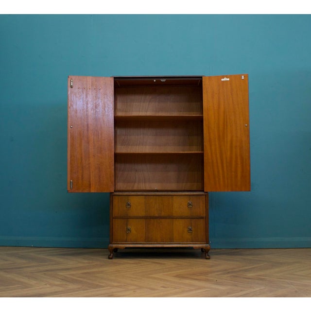 Beithcraft tallboy in walnut veneer with bookmatched grain and shaped panel doors in an Art Deco style. Original drop...