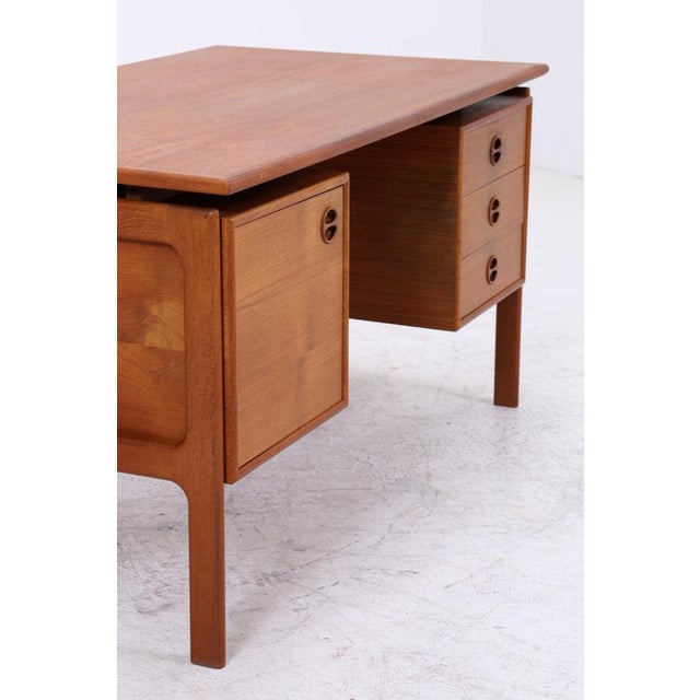 Vintage teak desk by Arne Vodder featuring the typical organic details of Danish Modern design. The delicate handle...
