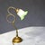 The lamp incorporates several hallmark art nouveau characteristics: whiplash curve – the flowing, asymmetrical brass stem...