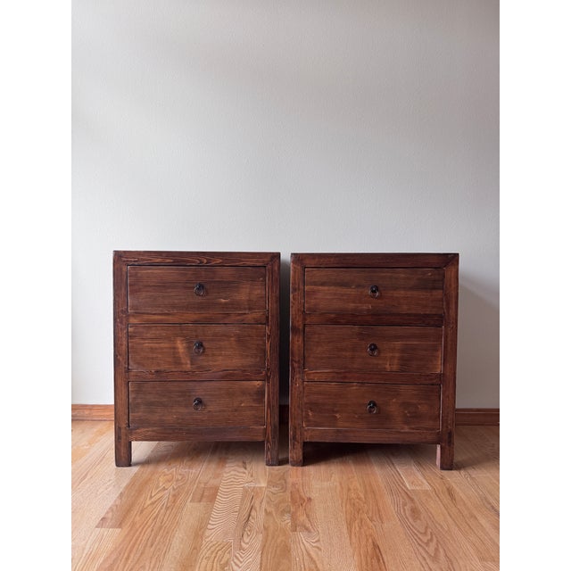 A substantial pair of rustic three-drawer bedside chests by Circa Loft, featuring beautifully textured wood, a warm,...