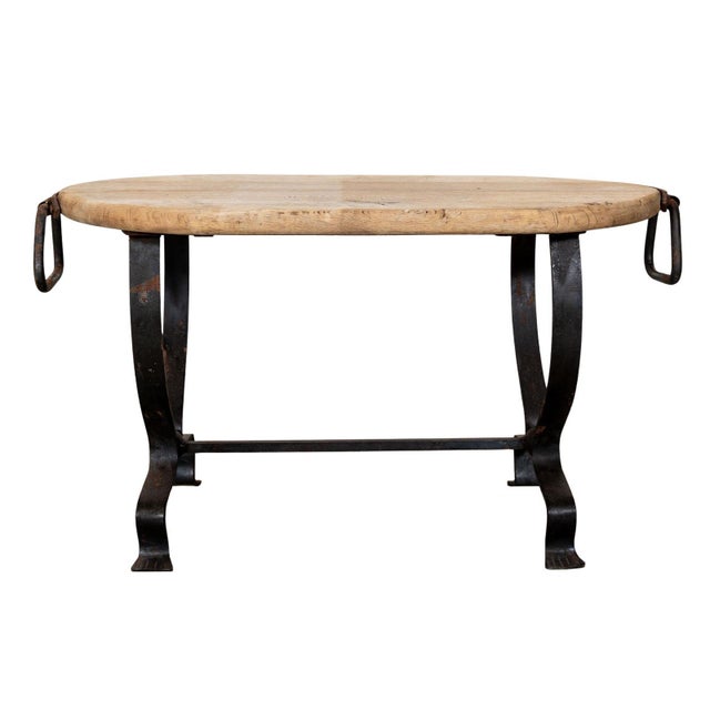 Oval cocktail table with wooden top and curved iron feet. Original iron handles.