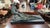 An expressive, dynamic sculpture depicting a fisherman leaning forward while hauling in a heavy net. Featuring a weathered...