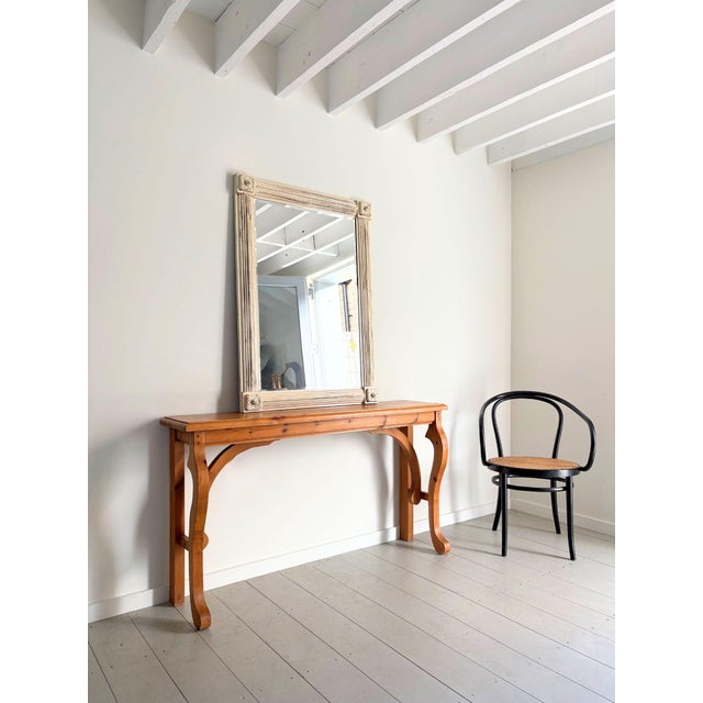 A vintage console in solid pine with a simple yet decorative design featuring curved and scrolled legs. This wooden table...