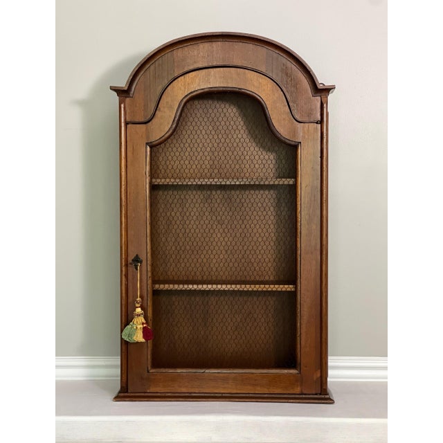 Italian country style hanging wood cabinet with a chicken wire door and key with lock, Italy, mid to late 20th century. A...