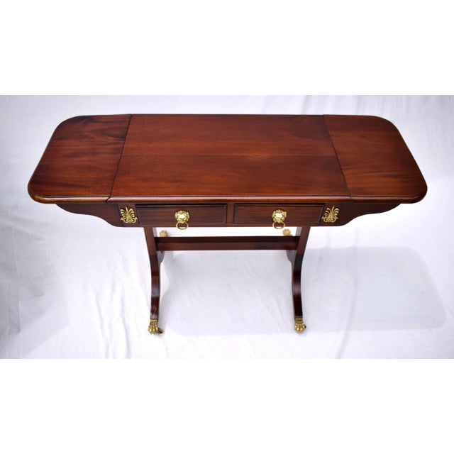 Regency style Mahogany drop-leaf sofa table with two fitted dovetail drawers, embellished with brass ornamentation & lions...