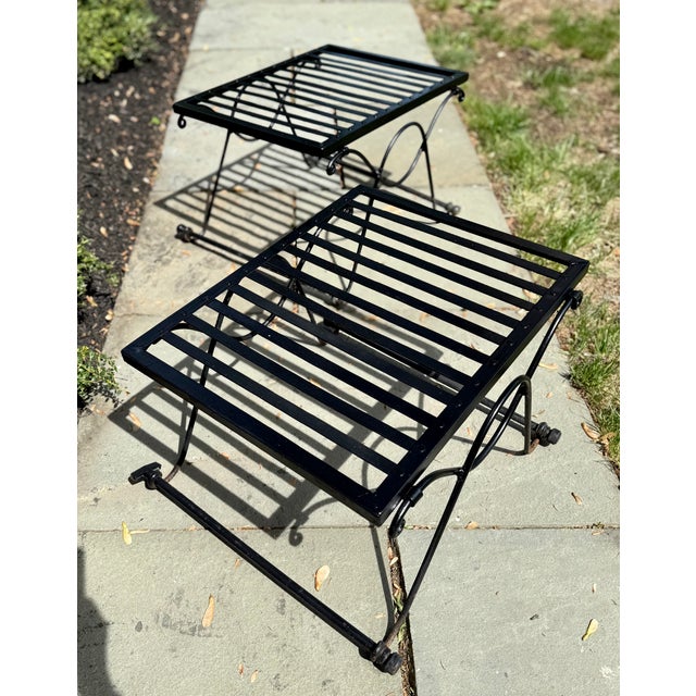 Salterini wrought iron tables with scrolled bases and slat tops. No glass. Circa 1930s. There is no maker's mark but brand...