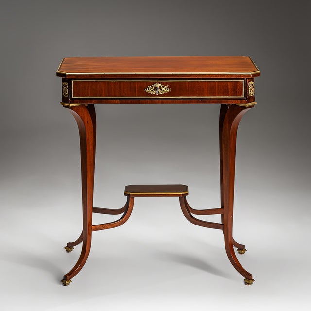 An elegant Viennese Empire side table in mahogany, crafted around 1810. The table features a single drawer and rests on...