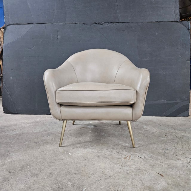 This very attractive Mid Century Modern Style Leather Vanessa Chair from Olivia Quinn is set on satin brass finish metal...